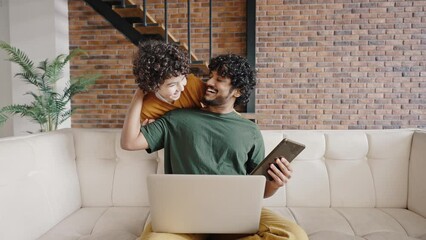 Cute biracial boy distracts father from work on laptop - Powered by Adobe