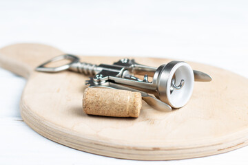 Cork and corkscrew on wood board
