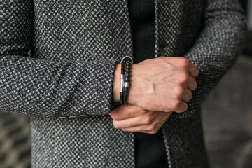 Businessman holds hands together. Man in a gray coat jacket. Stylish men's accessories up close.