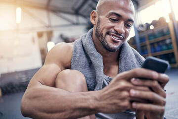 This app is amazing for tracking my results. Shot of a muscular young man using a cellphone while...