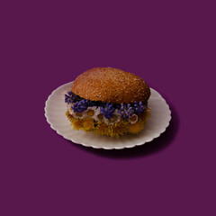 Spring decoration, sandwich with flowers on a white plate and purple background