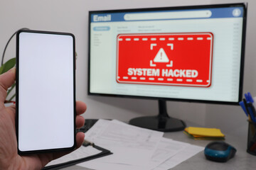 Hand holding mobile phone with white screen for copy space. System hacked alert after cyber attack on computer network.  Business computer hacked. Malicious software, virus and cybercrime on monitor.