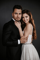 Wedding couple in love. Beautiful bride and elegant groom on black background. Stylish newlywed couple. Marriage concept