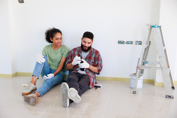 Portrait Cheerful couple young man and black woman smiling during renovation in new apartment