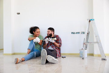 Portrait Cheerful couple young man and black woman smiling during renovation in new apartment