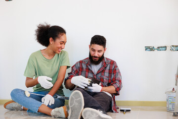 Portrait Cheerful couple young man and black woman smiling during renovation in new apartment