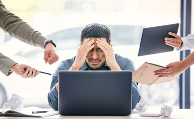 Maybe if I ignore them, theyll go away. Shot of a handsome young businessman sitting in the office and feeling stressed while his colleagues put pressure on him.