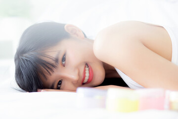 Obraz na płótnie Canvas Beautiful of young asian woman smiling and lying on bed at bedroom, beauty of girl with hygiene and healthy, cream and lotion and skin care, cosmetic and makeup, skincare and lifestyles concepts.