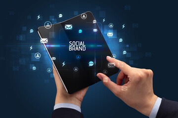 Businessman holding a foldable smartphone, social media concept
