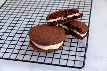 Homemade chocolate sandwich cookies. Light marble background.