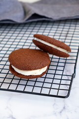 Homemade chocolate sandwich cookies. Light marble background. Selective focus.
