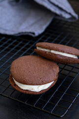 Homemade dark chocolate vegan brownie cookies with cream. Dark background. Selective focus.