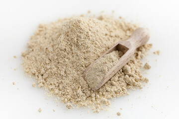Wooden scoop of almond flour isolated on white background.