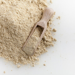 Wooden scoop of almond flour isolated on white background.