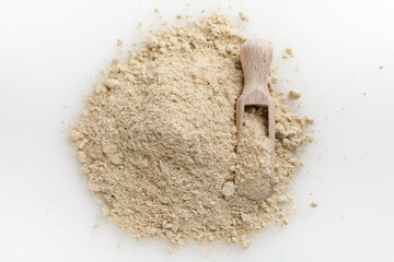 Wooden scoop of almond flour isolated on white background.
