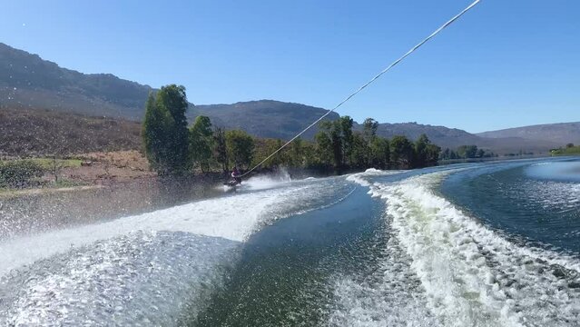 Woman on kneeboard behind speed boat on Bulshoek Dam, South Africa