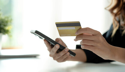 Asian woman checking online order details on smartphone Close control of credit card information entered.