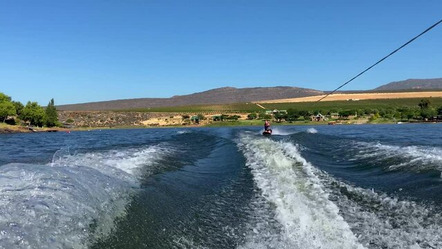 Woman on kneeboard behind speed boat on Bulshoek Dam, South Africa