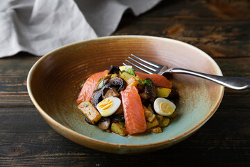Salad of fried potatoes, mushrooms and salmon