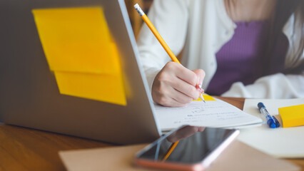 Closeup hand young adult women writing note for study and work online in yellow theme color