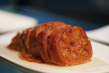 close up Sliced Lotus Root With Sweet Sauce on plate. Traditional Chinese snack