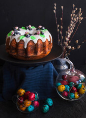 Traditional Easter cake and painted eggs on a wooden table. Easter pastries. - 499415071