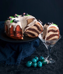 Traditional Easter cake and painted eggs on a dark background. Easter pastries. - 499415078