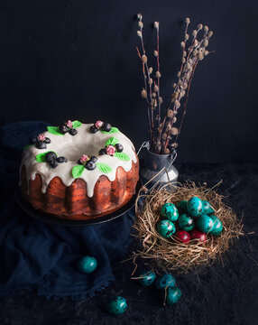 Traditional Easter cake and painted eggs on a dark background. Easter pastries.