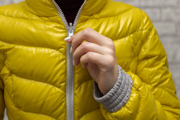 a woman zips up her jacket around her throat