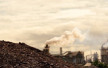 Pile of brown bottle for recycle in recycling factory. Glass waste for recycle. CO2 emissions....