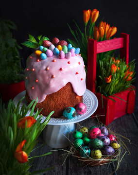 Traditional Easter cake and painted eggs on a wooden table. Easter pastries.