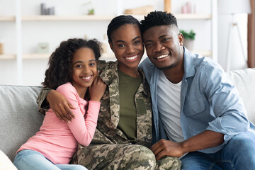 Family portrait of happy black kid, husband and military wife - Powered by Adobe