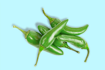 Bunch of hot green jalapeno peppers isolated on blue, top view.