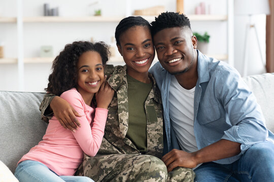 Family portrait of happy black kid, husband and military wife