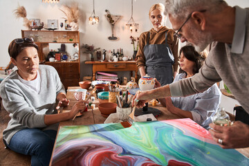 Man drawing vivid abstract fresh masterpiece with wet paints at the art master class