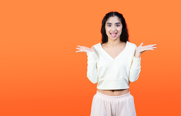 Funny stupid facial expression. Concept with brunette woman on orange background with copy space.