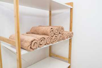 Lots of rolled towels on a shelf in a beauty salon, massage parlor and barbershop.