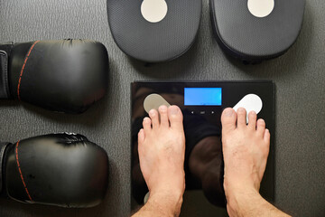 top view of man weighing and boxing equipment