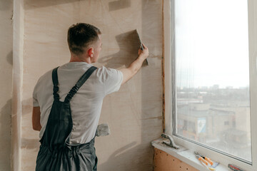 Worker applying putty mortar on the balcony wall