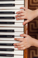kid hands on a white piano key