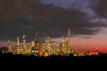 Obraz na płótnie Canvas Oil​ refinery​ and​ plant and tower column of Petrochemistry industry in pipeline oil​ and​ gas​ ​industry with​ cloud​ slowing red sky