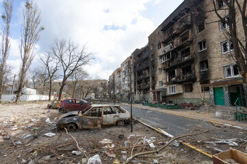Irpen city, Ukraine, April 11, 2022. War of Russia against Ukraine. Burnt-out car against the background of a burned-out house