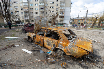 Irpen city, Ukraine, April 11, 2022. War of Russia against Ukraine. Burnt out car in the yard of a residential building
