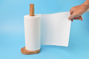 Hand picking a white tissue from tissue roll
