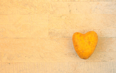 Obraz premium Heart shaped potato over stone background