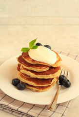 Pile of banana pancakes with cream on top