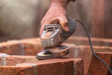 A man drags some bricks during bulding a stonewall