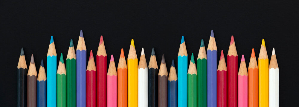 Color pencils set, row wooden color pencils colored pencils for drawing on matte black background. copy space
