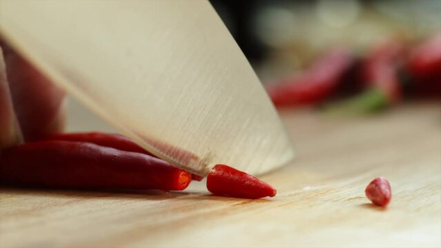 Slow motion 4K cutting red chili paper 