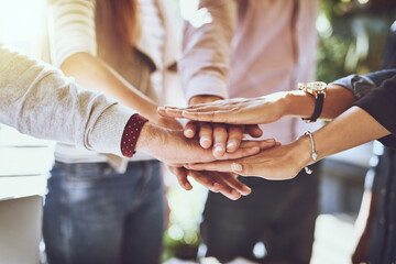 The power of togetherness. Shot of a group of colleagues joining hands in solidarity outdoors.